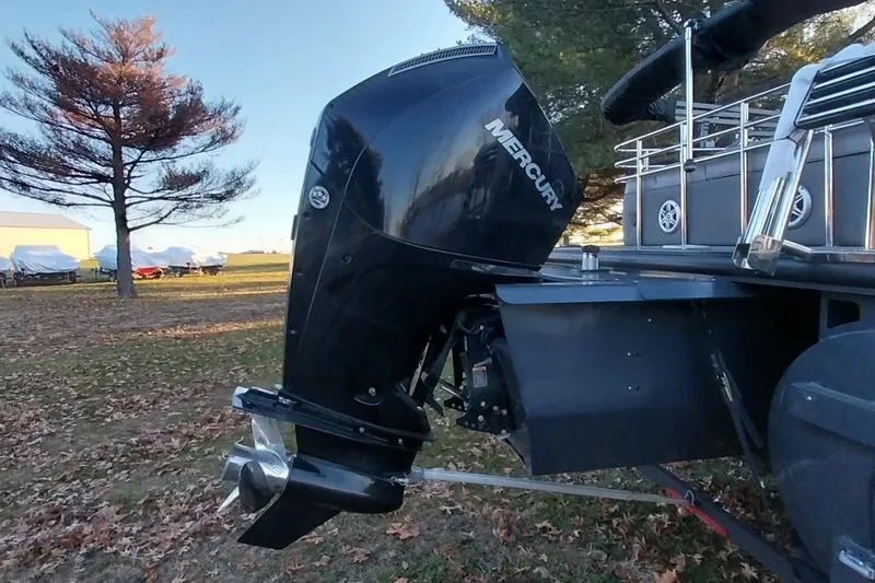 Slide: The Image of Outboard motor on 2021 Regency 230 LE3 Sport boat, parked on grassy area. - 27
