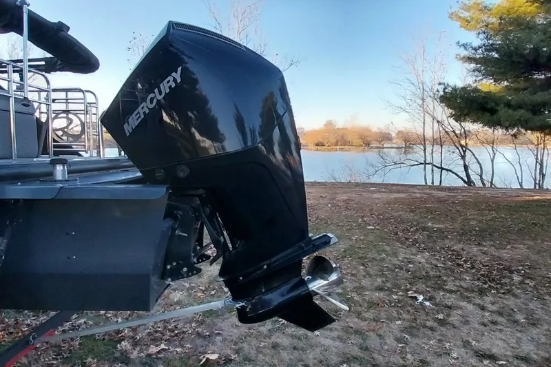Slide: The Image of 2021 Regency 230 LE3 Sport boat with Mercury outboard motor by a lake. - 30