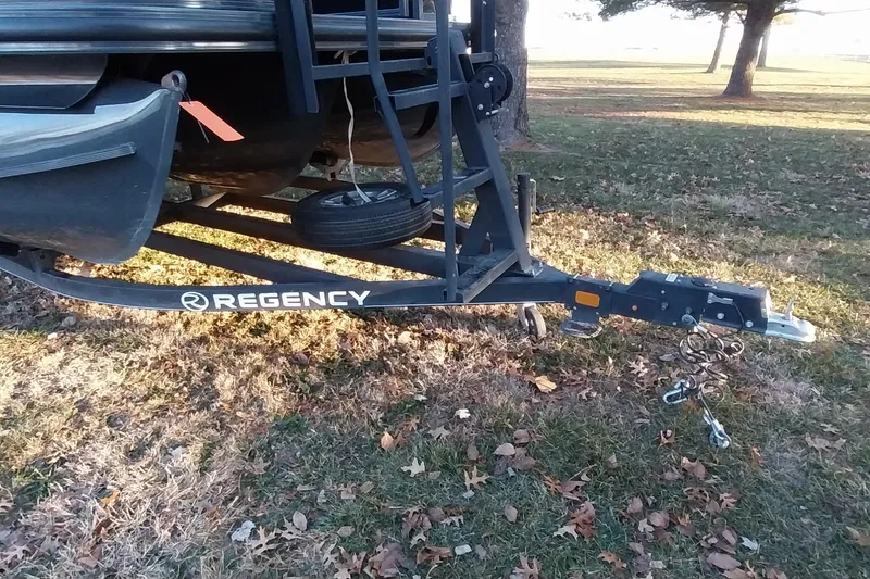Slide: The Image of Trailer hitch of a 2021 Regency 230 LE3 Sport boat on grass. - 35