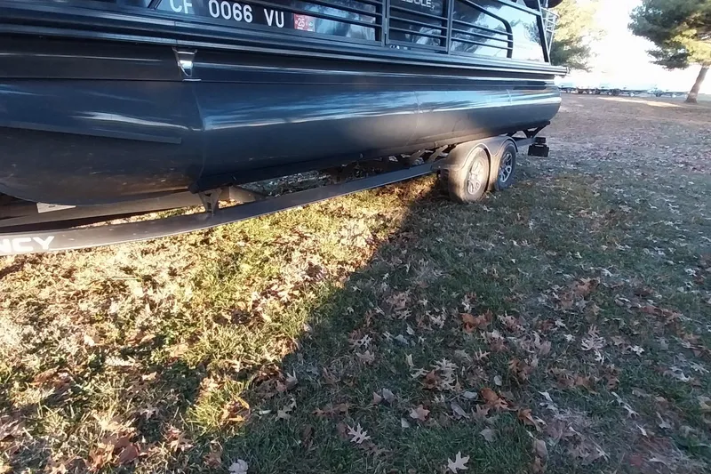 Slide: The Image of 2021 Regency 230 LE3 Sport boat on trailer, parked on grassy area. - 4