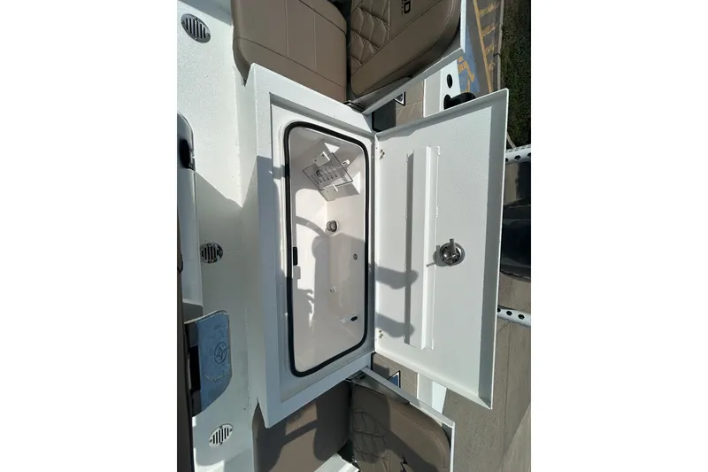 Slide: The Image of Open storage compartment on 2026 Avid 21 Mag boat, featuring a secure latch and spacious interior. - 10
