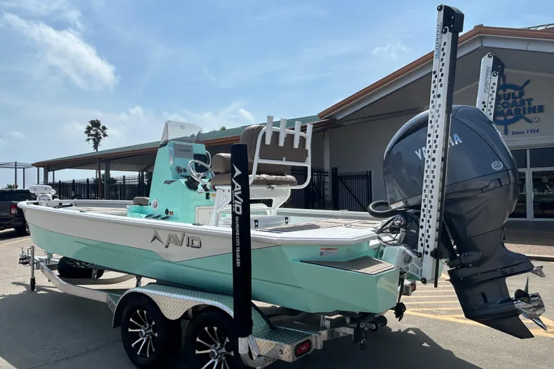 Slide: The Image of Avid 21 Mag 2026 boat with Yamaha engine on trailer, parked outdoors. - 2