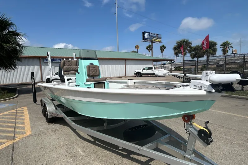Slide: The Image of 2026 Avid 21 Mag boat on trailer, mint green hull, parked outdoors. - 3