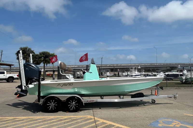 Slide: The Image of Avid 21 Mag 2026 boat on trailer, parked outdoors under blue sky. - 4