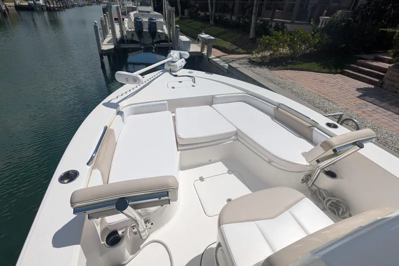 Slide: The Image of 2021 Robalo 226 Cayman boat interior with white seating and fishing rod holders. - 4