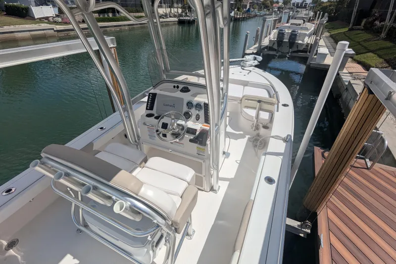 Slide: The Image of 2021 Robalo 226 Cayman boat docked in a canal, featuring a sleek console and seating. - 6