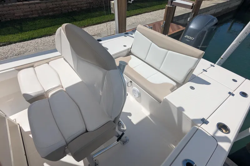 Slide: The Image of 2021 Robalo 226 Cayman boat interior with cushioned seating and Yamaha 200 engine. - 7
