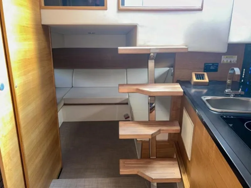 Slide: The Image of Interior of 2023 De Antonio Yachts D42 Open, featuring modern wooden stairs and compact kitchen. - 14