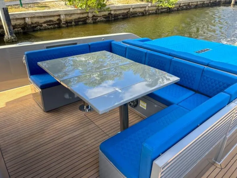 Slide: The Image of De Antonio Yachts D42 Open 2023 model with blue seating and a sleek dining table. - 24