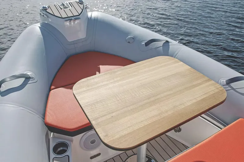 Slide: The Image of Manufacturer Provided Image: Zodiac Medline 5.8 2026 with wooden table and orange seats on water. - 3