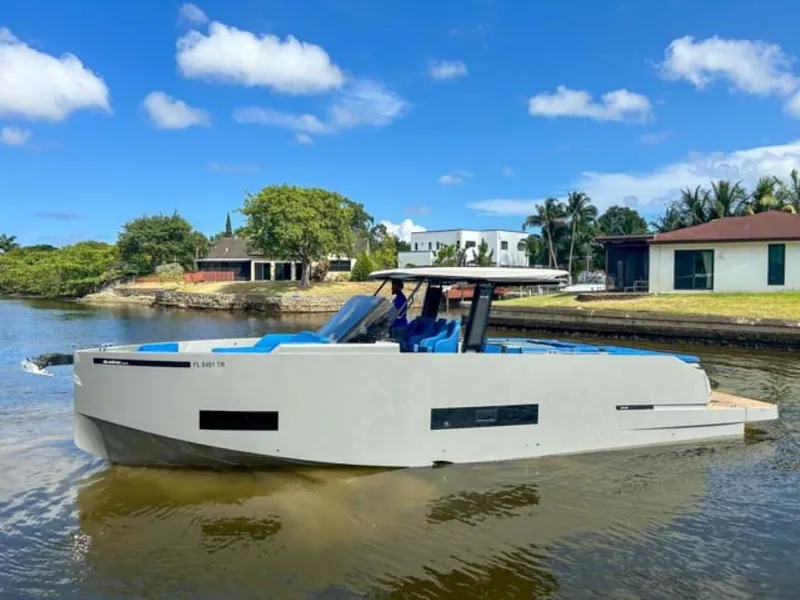 The Image of 2023 De Antonio Yachts D42 Open cruising on a sunny day near waterfront homes. - 0