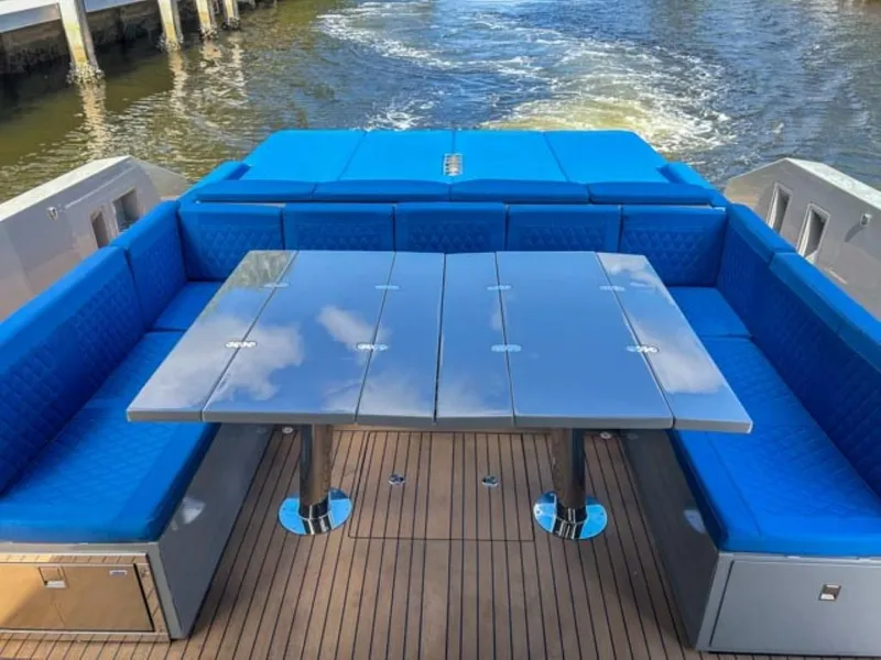 Slide: The Image of De Antonio Yachts D42 Open 2023 model with blue seating and a sleek dining area. - 23