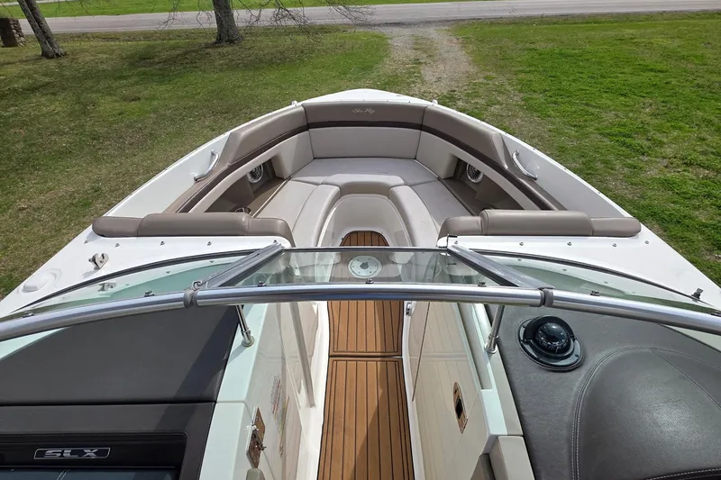 Slide: The Image of 2011 Sea Ray SLX 250 boat interior with cushioned seating and wooden flooring. - 14