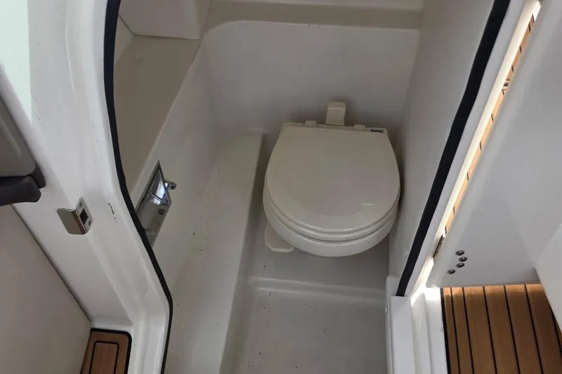 Slide: The Image of 2011 Sea Ray SLX 250 boat bathroom with white toilet and compact design. - 18