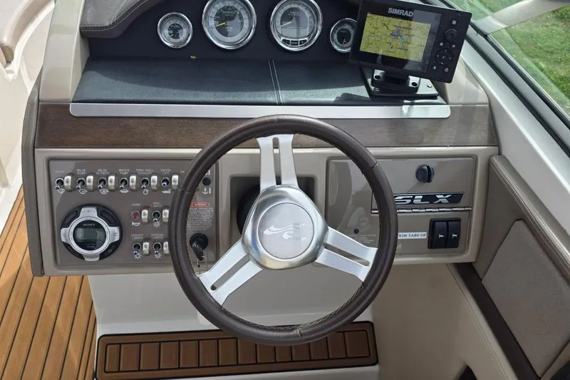 Slide: The Image of 2011 Sea Ray SLX 250 dashboard with steering wheel, controls, and navigation display. - 20