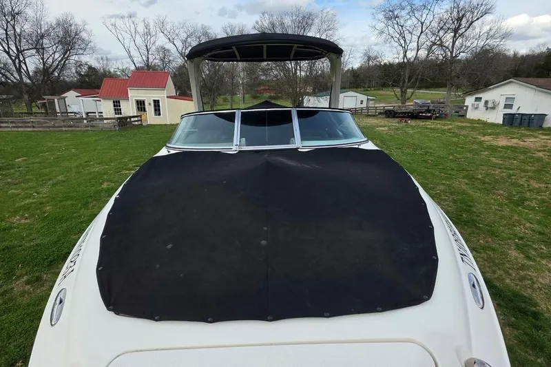 Slide: The Image of 2011 Sea Ray SLX 250 boat with black cover on grassy area. - 33