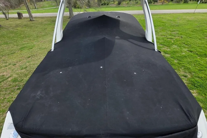 Slide: The Image of 2011 Sea Ray SLX 250 boat with black cover on grassy area. - 34