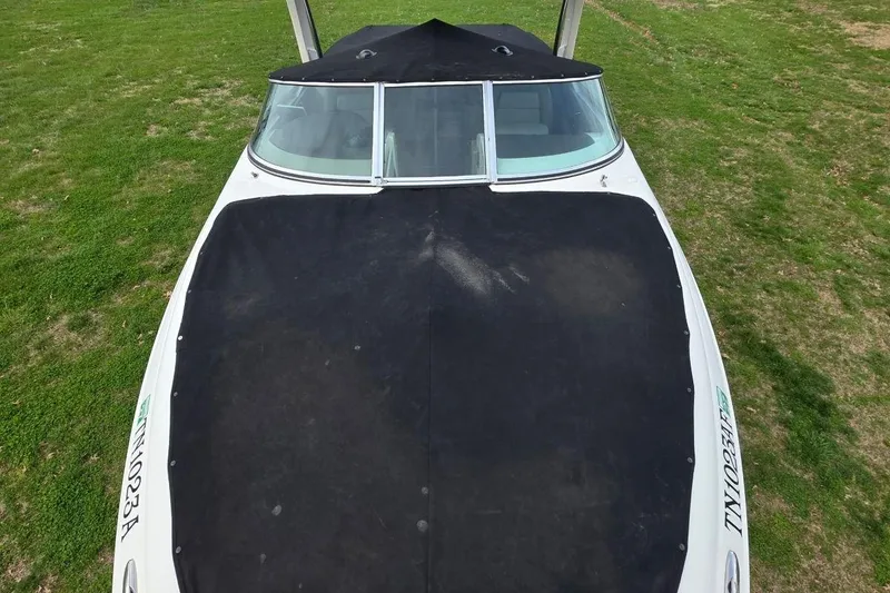 Slide: The Image of 2011 Sea Ray SLX 250 boat with black cover on grassy field. - 35