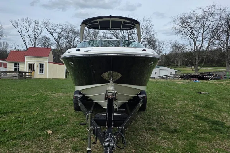 Slide: The Image of 2011 Sea Ray SLX 250 boat on trailer, parked on grassy area near red-roofed buildings. - 4