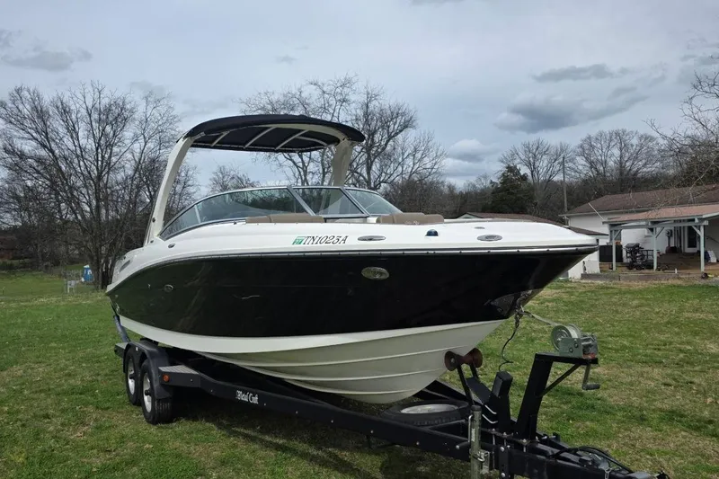 Slide: The Image of 2011 Sea Ray SLX 250 boat on trailer in grassy yard, overcast sky. - 5