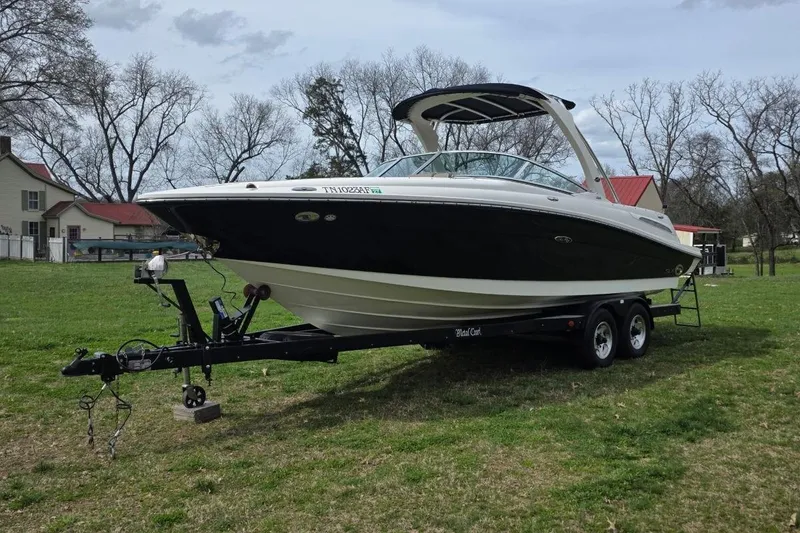 Slide: The Image of 2011 Sea Ray SLX 250 boat on trailer in grassy area, overcast sky. - 9