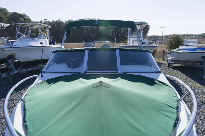 The Image of 2004 Scout 175 Dorado boat with green cover, parked outdoors. - 1