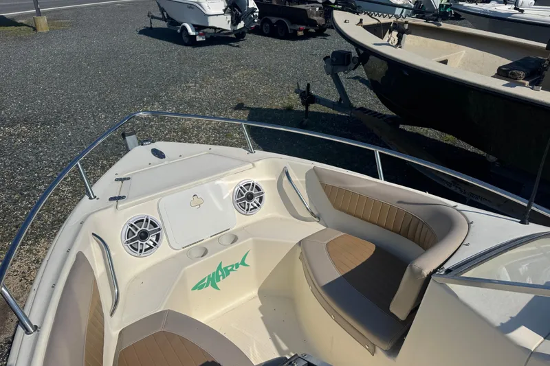 Slide: The Image of 2004 Scout 175 Dorado boat with seating and speakers, parked on gravel. - 10