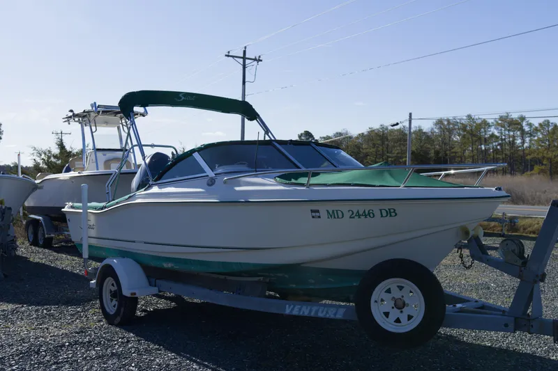 Slide: The Image of 2004 Scout 175 Dorado boat on trailer, parked outdoors with green cover. - 5