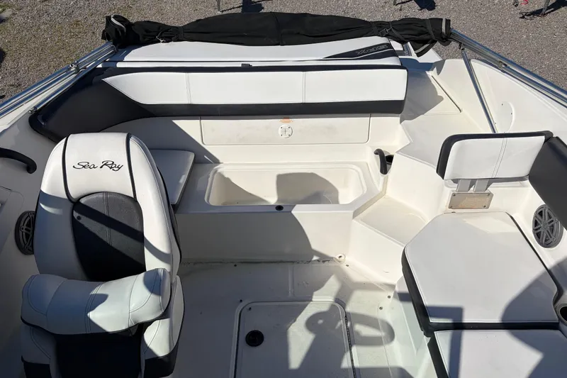 Slide: The Image of Interior of a 2015 Sea Ray 19 SPX boat with white seating and storage compartments. - 10
