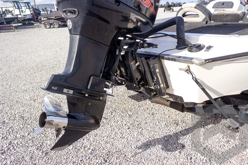 Slide: The Image of Outboard motor on a 2000 Champion 193 CX boat, displayed on gravel. - 16