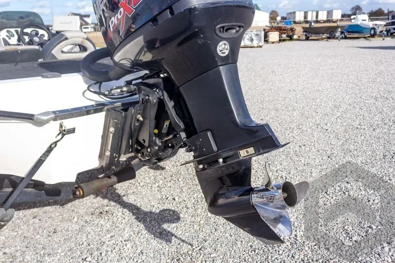 Slide: The Image of Outboard motor on a 2000 Champion 193 CX boat, parked on gravel. - 17