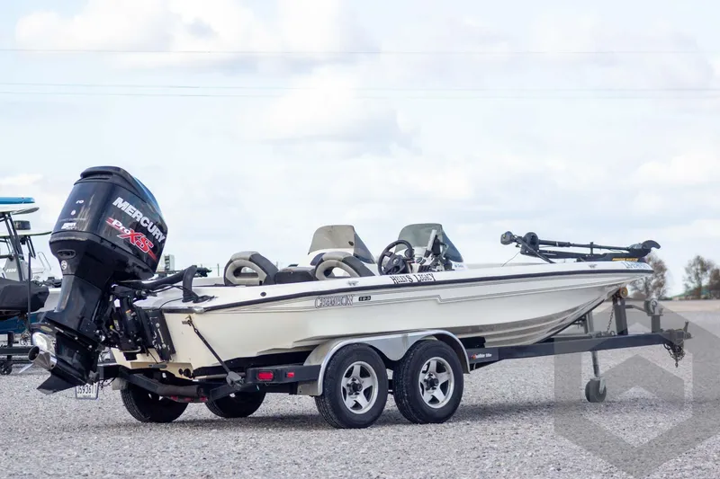 Slide: The Image of 2000 Champion 193 CX boat with Mercury engine on a trailer, parked outdoors. - 3