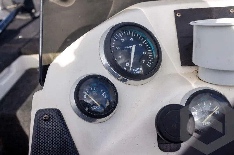 Slide: The Image of Dashboard of a 2000 Champion 193 CX boat with RPM and volt gauges. - 30