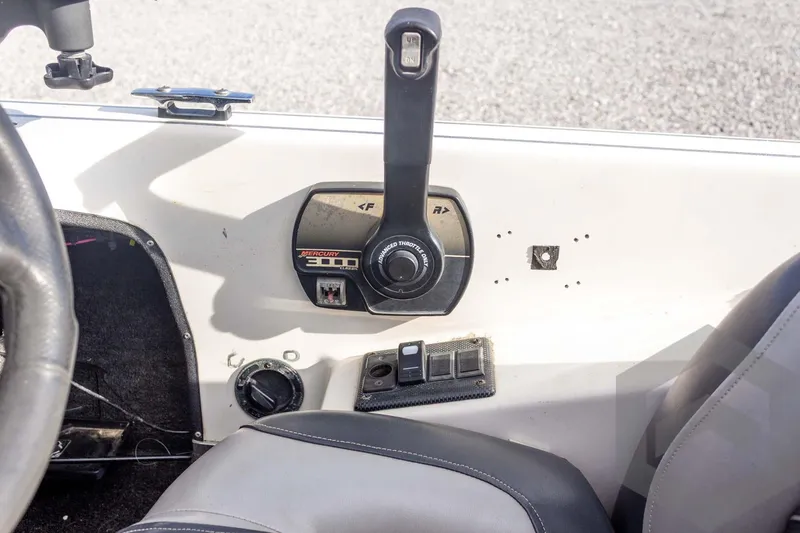 Slide: The Image of Interior of a 2000 Champion 193 CX boat showing control panel and throttle lever. - 31
