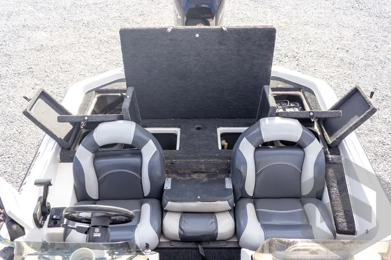 Slide: The Image of 2000 Champion 193 CX boat interior with open storage compartments and dual seats. - 36