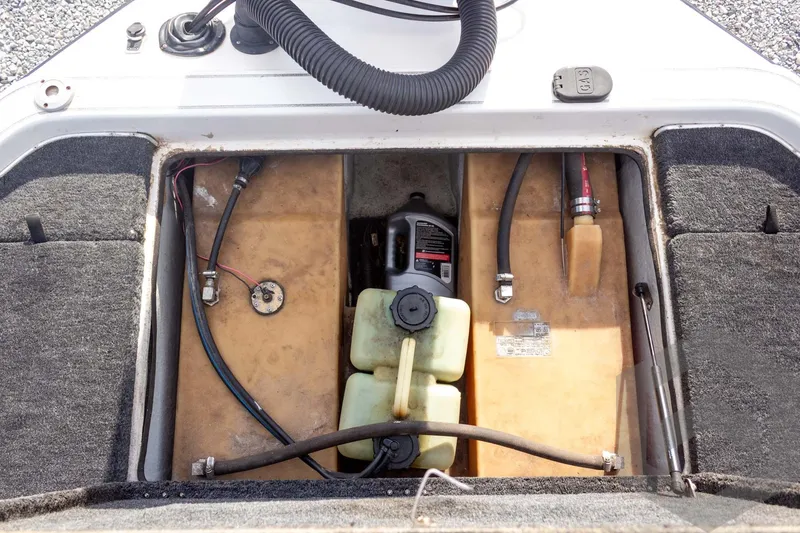 Slide: The Image of Open engine compartment of a 2000 Champion 193 CX boat, showing fuel and oil tanks. - 43