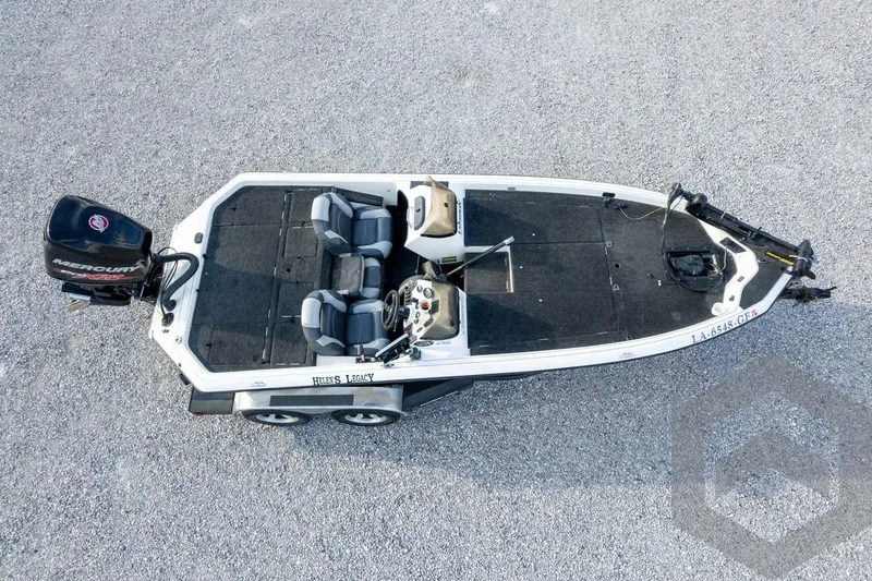 Slide: The Image of Aerial view of a 2000 Champion 193 CX boat on gravel, featuring dual seats and a Mercury engine. - 50