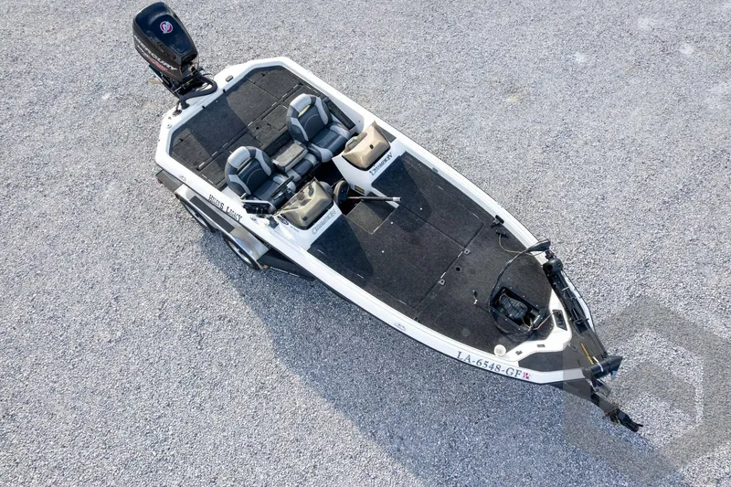 Slide: The Image of 2000 Champion 193 CX boat on gravel, aerial view, featuring dual seats and motor. - 51