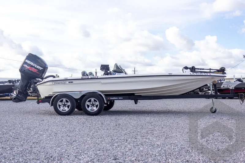 Slide: The Image of 2000 Champion 193 CX boat with Mercury engine on trailer, parked on gravel lot. - 7