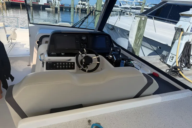 Slide: The Image of Helm of 2023 Aquila 36 Sport boat with modern controls and steering wheel. - 16