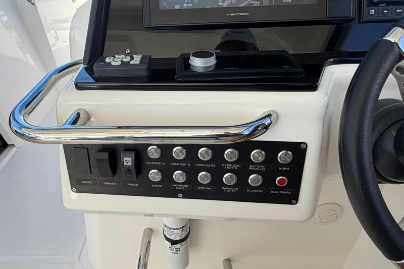 Slide: The Image of Control panel of 2023 Aquila 36 Sport boat with various switches and steering wheel. - 17