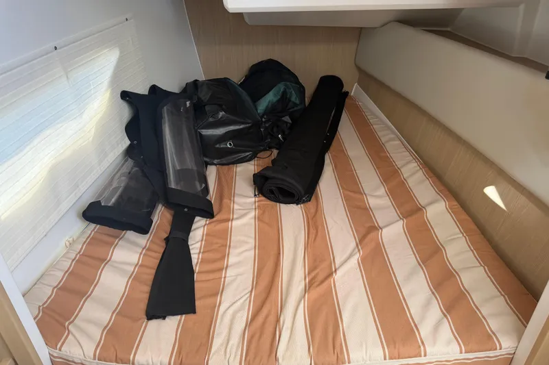 Slide: The Image of Interior cabin of 2023 Aquila 36 Sport with striped bedding and gear. - 25