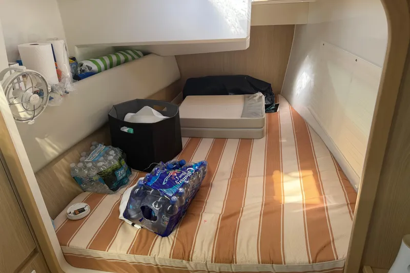 Slide: The Image of Interior cabin of 2023 Aquila 36 Sport with striped bedding and supplies. - 26