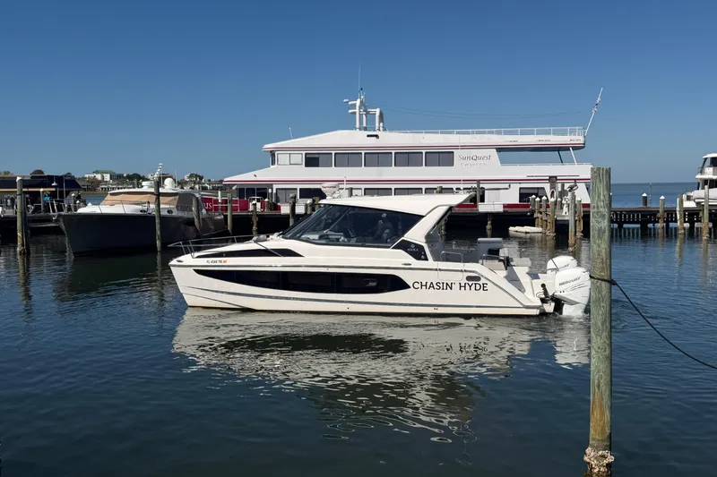 Slide: The Image of 2023 Aquila 36 Sport boat docked in marina, clear blue sky background. - 3
