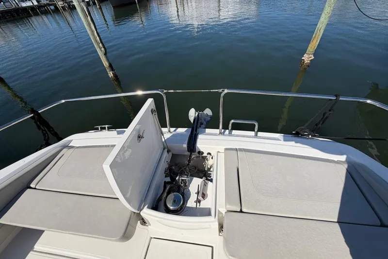 Slide: The Image of 2023 Aquila 36 Sport boat deck with open storage compartment and water view. - 31