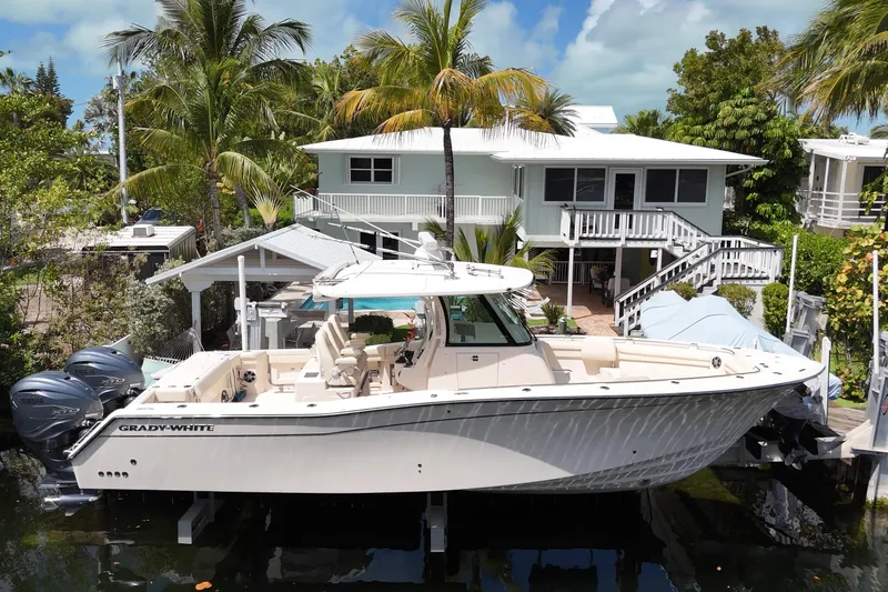 The Image of 2021 Grady-White Canyon 336 boat docked near tropical house with palm trees. - 0