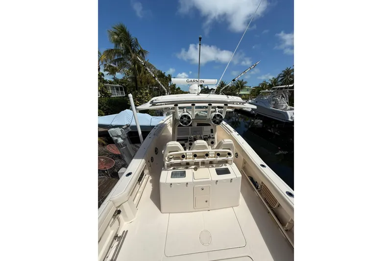 Slide: The Image of 2021 Grady-White Canyon 336 boat interior with helm, under clear blue sky. - 13