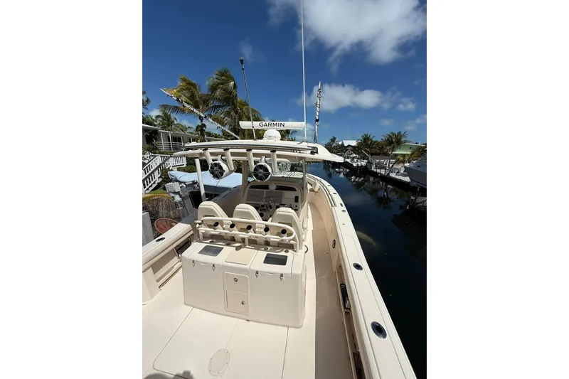 Slide: The Image of 2021 Grady-White Canyon 336 boat docked, featuring helm and seating area under clear blue sky. - 14