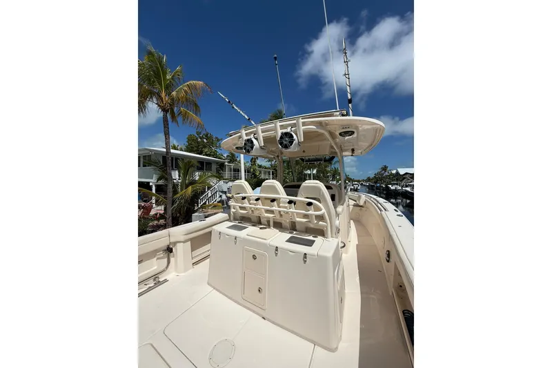 Slide: The Image of 2021 Grady-White Canyon 336 boat, spacious deck, palm trees, clear blue sky. - 15
