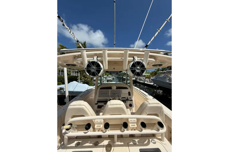Slide: The Image of 2021 Grady-White Canyon 336 boat interior with helm and speakers under clear blue sky. - 18